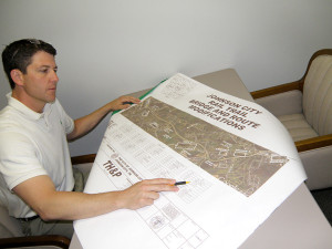 Mitch Cox Companies' Raymond McBride reviews plans for the Tweetsie Trail bridge modification. Photo by Tammy Childress.