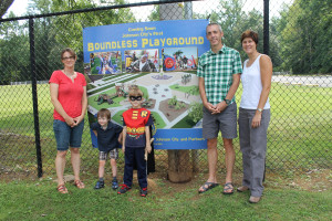Allison Maines, her sons Vadin and Guthrie Jones, and Rotary Club Boundless Playground co-chairs Mike Mefford and Shelley Brouillette at the park entrance.
