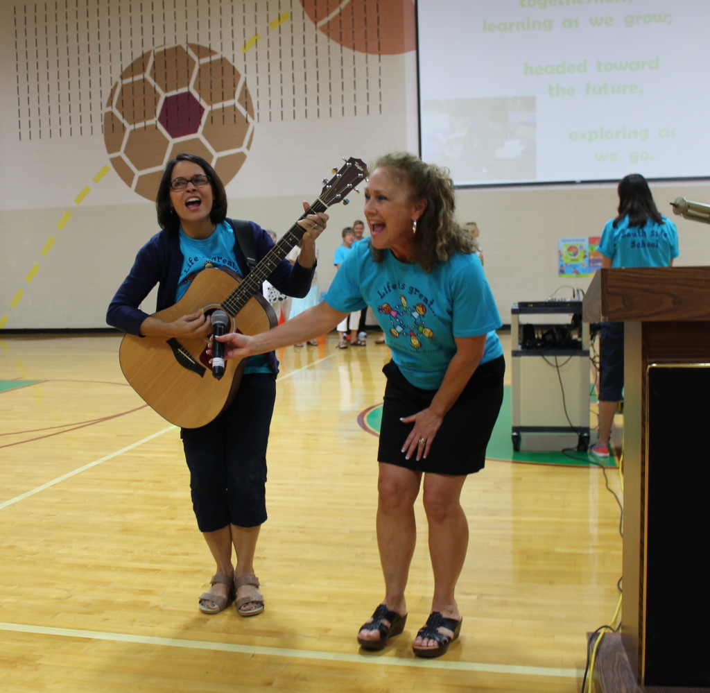 Anne Littleford helps music teacher Doris Reed lead the assembly in South Side's very own theme song.