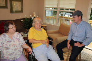 Edna Price, left, and Mindy Price enjoy conversation with Boone Trail Baptist Church worship minister Josh Lake inside the Prices' new home.