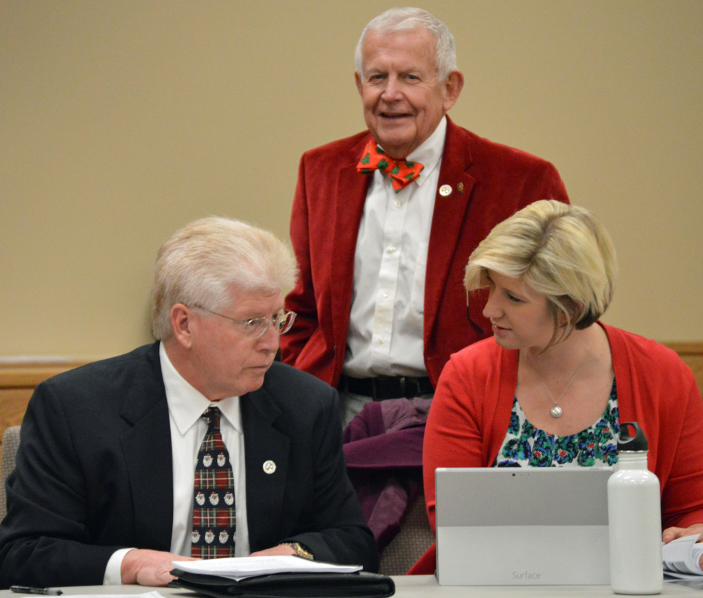 Festively dressed county commissioners including Larry England, Skip Oldham and Katie Baker heard tidings of neither comfort nor joy in an economic report at the Dec. 15 commission meeting. (Photo by Scott Robertson)
