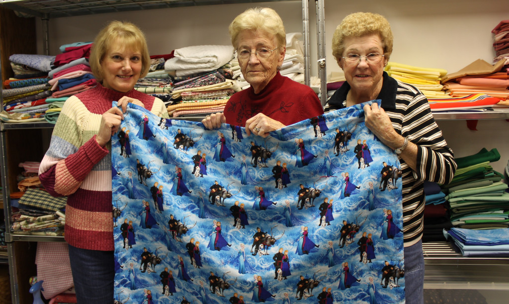 Linda Cole, Norma Dean Holt and Emma Scott with one of many 'Frozen' quilts the group has sewn recently.