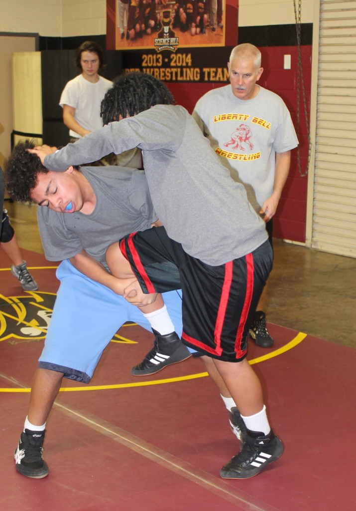 Kain Rogers, left, goes for a single-leg takedown of teammate Vegas Wells under the tutelage of Liberty Bell assistant coach Bill McKinney.