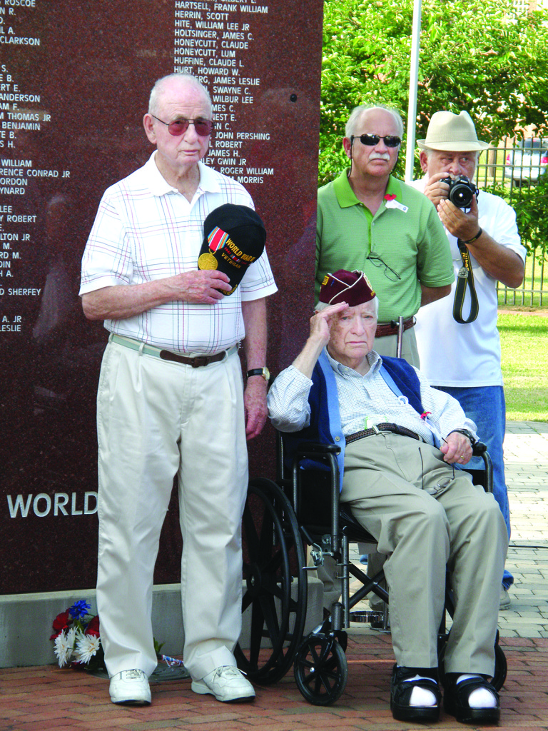 Ed Parker, left, honors his fallen brother, Robert B. Parker, killed in the Korean War. Roy B. Moore, right, a POW in Germany in WW II, salutes his fallen comrades.