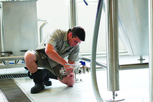 John Edwards prepares equipment at Yee-Haw’s brewery so that wort can be piped into a brewing tank for fermenting.
