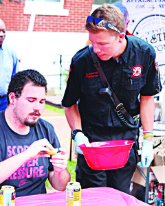 Hunter Estep of Jonesborough discards an orange. The contestants used a variety of oranges, lemons and lemonade to try and fight off the heat.