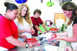 Tatiana Rhea, Jennifer Stout, Joey Brienze and Sherri Cooper prepare an order of tomatoes going to Gourmet and Company. Photos by Sarah Colson