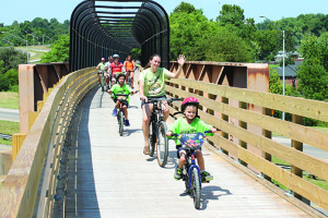 Some of the hundreds of Tweetsie Trek cyclists cross the trail’s longest bridge heading east on Aug. 30, 2014. Photos by Jeff Keeling