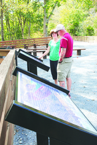 Cheri Tullis and Keith Edwards look at an interpretive sign explaining the varying geological formations along the trail. Photos by Jeff Keeling