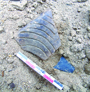 Pottery of the Lamar Incised style shared by Cherokees and other ethnic groups and found in the Boone Lake watershed by ETSU researchers. The stone arrow point was found next to it. The shard was dated by luminescence to the mid-1400s. Photo courtesy Jay Franklin.