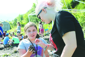 Casey Crumly, right, looks at a find with Gabrielle Puckett during paleo camp in July at the Gray Fossil Site. Photo by Sarah Colson