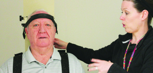 Dr. Stephanie Rouse (right) helps Glen Guy into the rotary chair during his most recent visit to the Mountain Home VA Medical Center. Photo by Sarah Colson