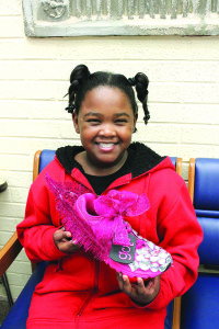 Copney proudly holds up GOTR North Side’s most recent award: the coveted “Pink Shoe.” Photo by Sarah Colsom