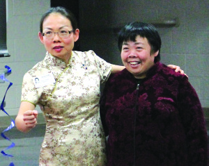 Dr. Huili Hong (right) with her mother, Shaomei Gao, proudly displaying a tapestry of the Great Wall of China during Towne Acres’ presentation by the International Moms Club. Gao spent two years making this piece and used 400 different kinds of thread.