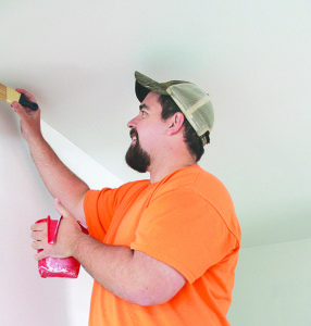 East Tennessee State University senior Jeremy Hensley paints a room Monday during construction of the Tredways’ new home.