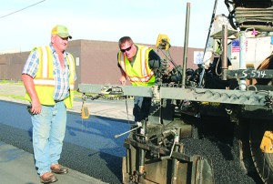 Summers-Taylor foreman Doug Cox, left, and screw man Chris Nickerson operate on West Walnut Street Friday. Photos by Jeff Keeling