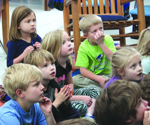 Reagan Sutterlin (upper left) sits with her classmates and listens intently to Mrs. Erin Ward during storytime. Photos by Sarah Colson
