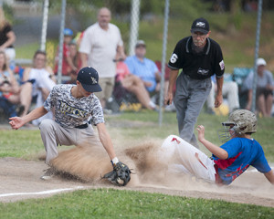 Lakebridge’s Ayden Connell slides in safely at third base, avoiding the tag of the Bucs’ Avery Stewart. Photos by Bart Nave. Photo galleries at: bart.ifp3.com