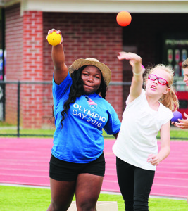 ETSU rising junior and weightlifting team member Jessica Kinsler works with 10-year old Hannah Eisenzopf on her shot put technique.