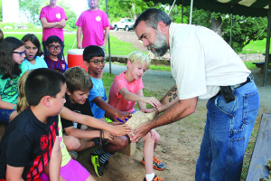 Dr. Steven Wallace of East Tennessee State University shows campers a fossilized tail section of a glyptodon, an Ice Age-era, armadillo-like creature. Photo by Jeff Keeling