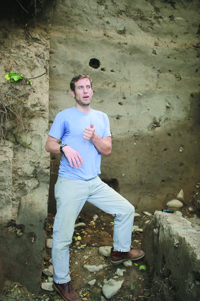 Nathan Shreve stands at the Cane Notch bank profile with original riverbed cobbles underfoot. Photo by Jeff Keeling
