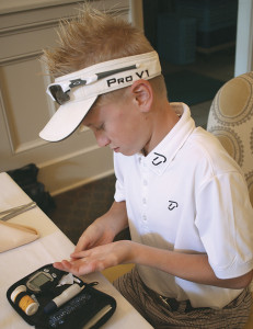Noah Turner checks his blood sugar, as he does every three holes while golfing. Photo by Jeff Keeling