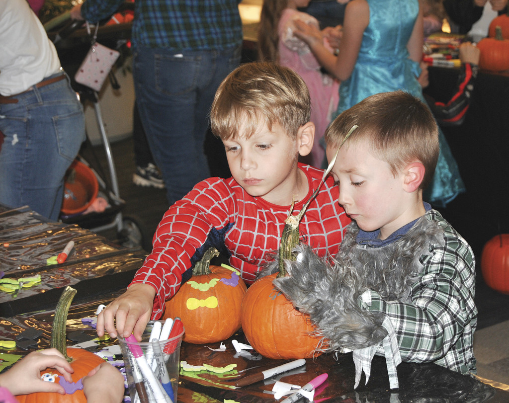 A pair of trick-or-treaters decorate a pumpkin during Saturday’s Halloween event at the Mall at Johnson City.
