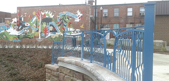Decorative steel railings are being set above the three culverts at King Commons in Downtown Johnson City. Workers with the Memphis Metal Museum - Jim Masterson, a master blacksmith, and Lewis Body, a designer - are installing the railings. The park is expected to open in February. PHOTOS BY GARY GRAY