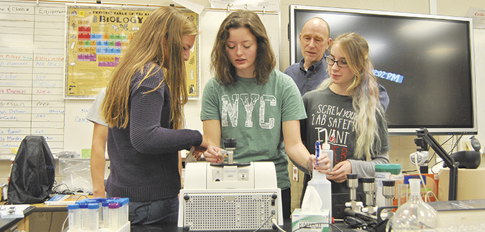 David Crockett students (left to right) Toni Schroeck, Alexis Freeman and Azaria Barnett operate the Fourier Transformed Infrared Spectrometer as their teacher David Yates looks on. PHOTO BY DAVE ONGIE