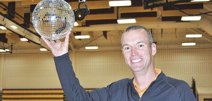 Indian Trail P.E. teacher David Nutter shows off the disco ball that helped transform the school's gym into a roller staking rink. PHOTO BY DAVE ONGIE