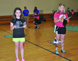 STEAM campers pilot their drones across the North Side gym and use a mounted cannon to knock down plastic cups. PHOTO BY DAVE ONGIE